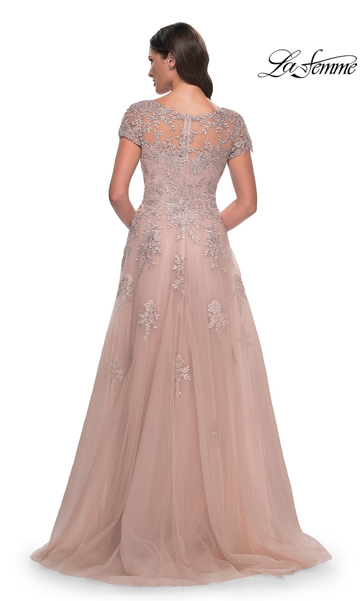 La Femme 30228 floor-length, blush-colored tulle evening gown with a sheer illusion neckline, cap sleeves, and silver floral embroidery.